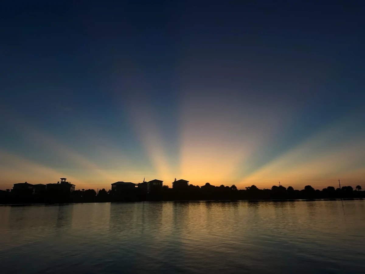 Sunset rays spreading across the sky above the waterfront